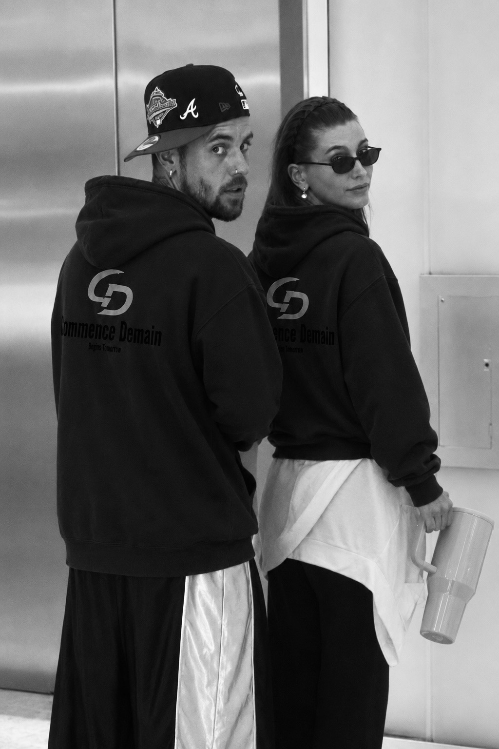 Commence Demain couple wearing matching back-print hoodies